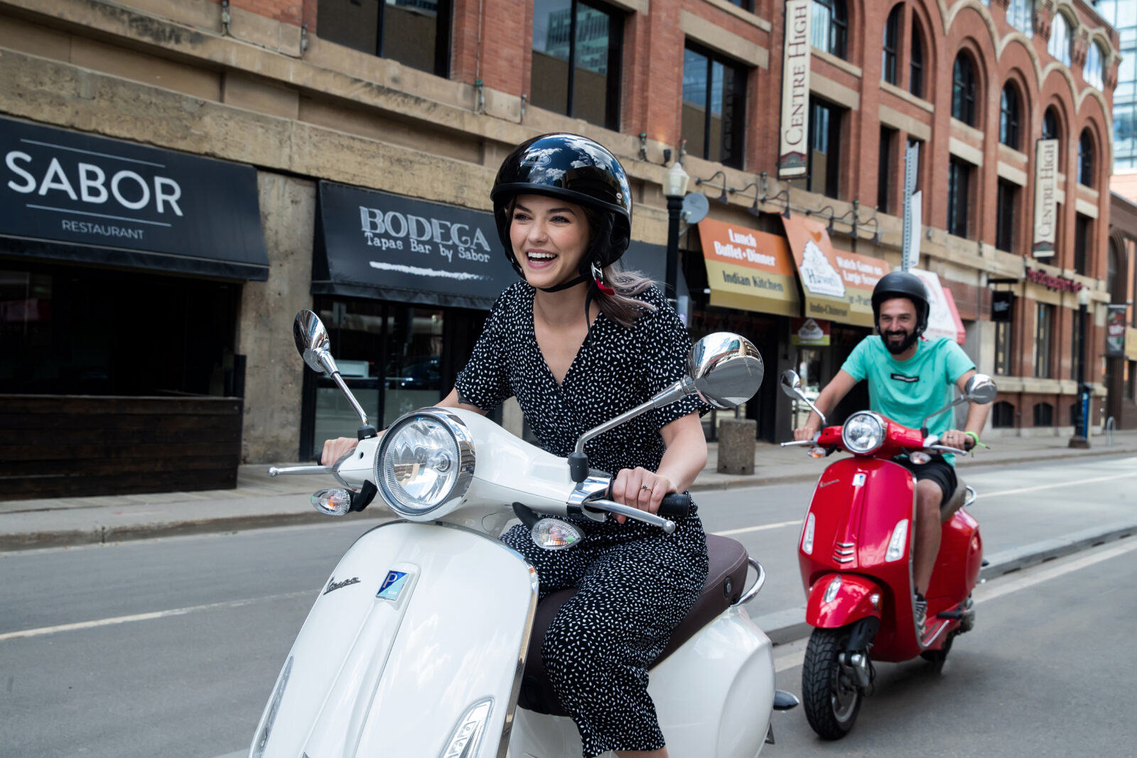 Man and women riding Vespas in Edmonton Downtown