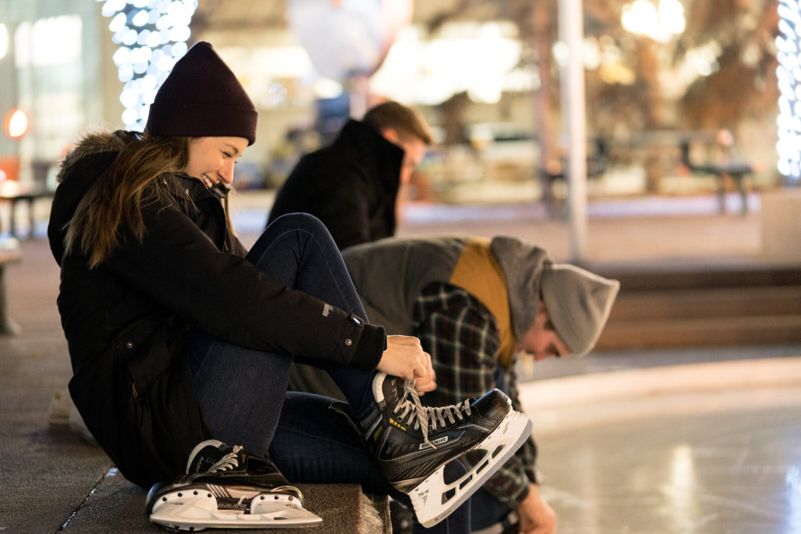 Young woman lacing up ice skates at Edmonton City Hall